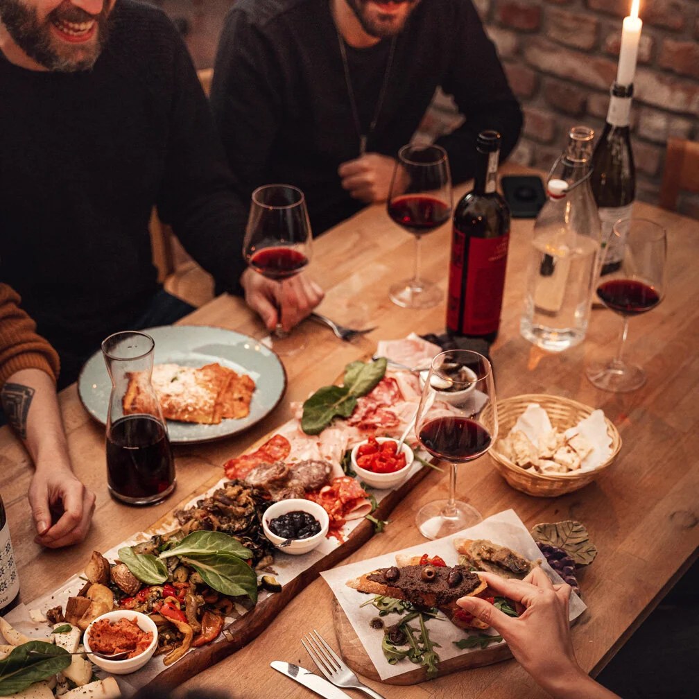 A table of Italian cheeses, cured meats and wine